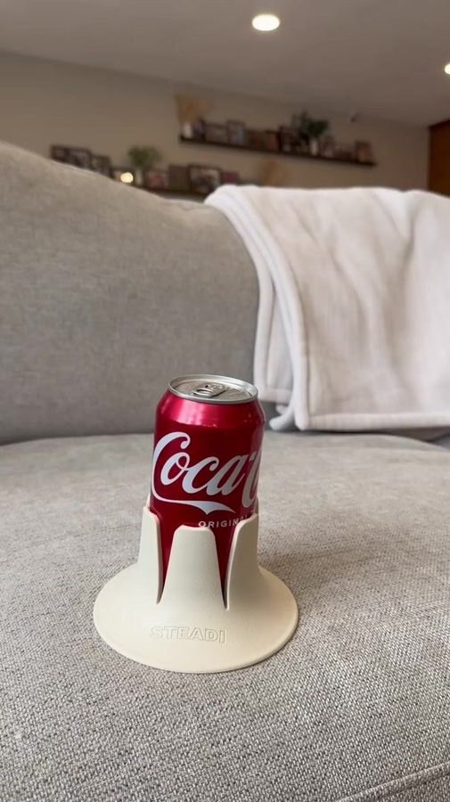 A full can standing in a white Steadi on a cushion.